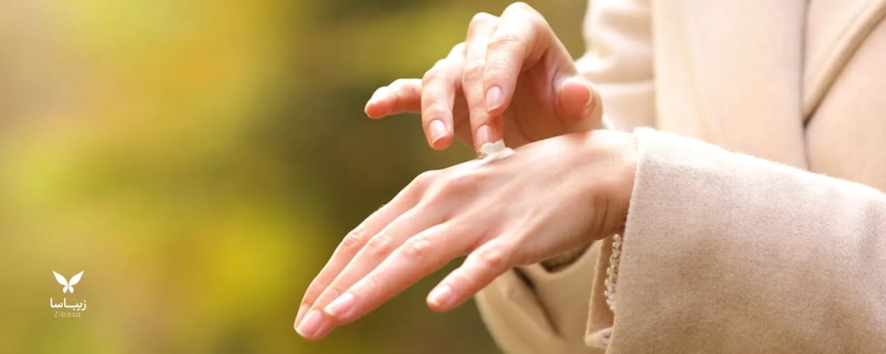زن در حال کرم زدن روی دست خود است